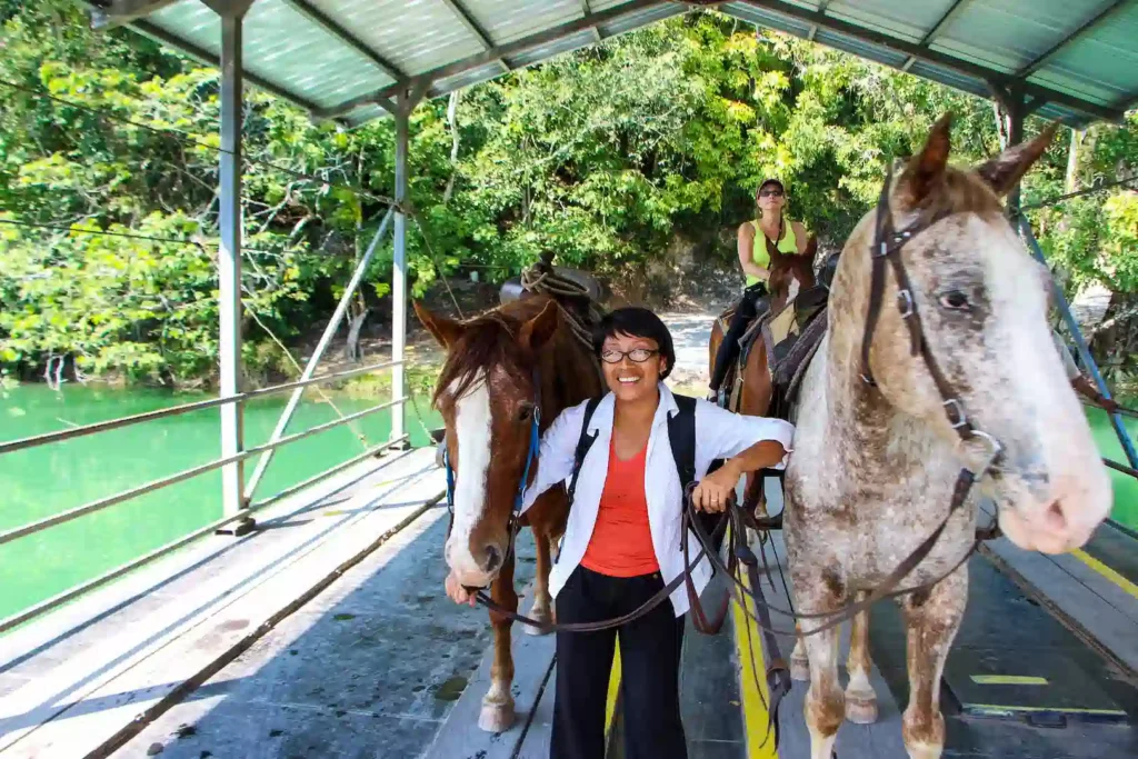 Guests horseback riding toward Xunantunich in western Belize